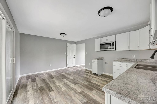 8486 US Route 127, West Manchester, OH 45382 - kitchen with stainless steel microwave, a sink, light wood-style flooring, and white cabinets