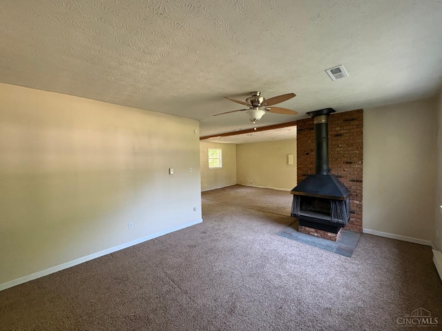 2307 Wilshire Cir, Stonelick Twp, OH 45122 - unfurnished living room with ceiling fan, a wood stove, carpet flooring, and a textured ceiling