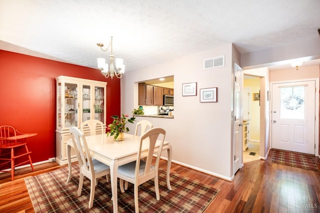 1627 Braintree Dr, Anderson Twp, OH 45255 - dining room featuring a chandelier, wood finished floors, a textured ceiling, and baseboards