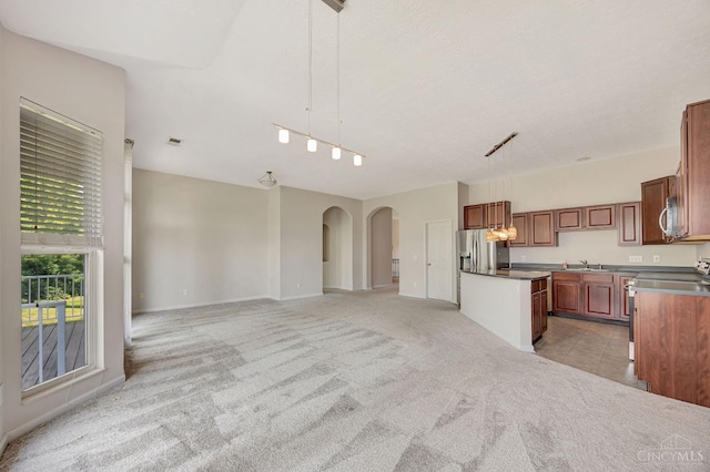 9298 Greenery Ct, Deerfield Twp, OH 45140 - kitchen with appliances with stainless steel finishes, light colored carpet, a sink, arched walkways, and pendant lighting