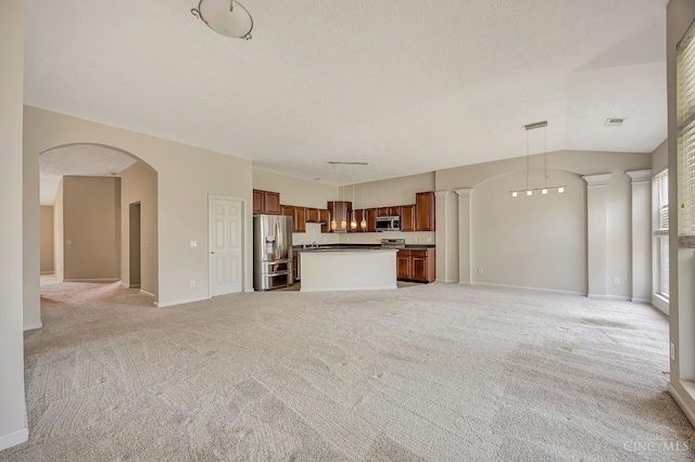 9298 Greenery Ct, Deerfield Twp, OH 45140 - unfurnished living room featuring light carpet, baseboards, vaulted ceiling, a textured ceiling, and arched walkways