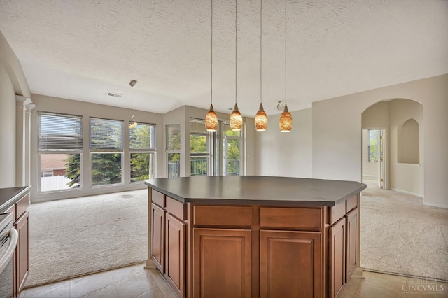9298 Greenery Ct, Deerfield Twp, OH 45140 - kitchen with light colored carpet, dark countertops, brown cabinets, and a textured ceiling
