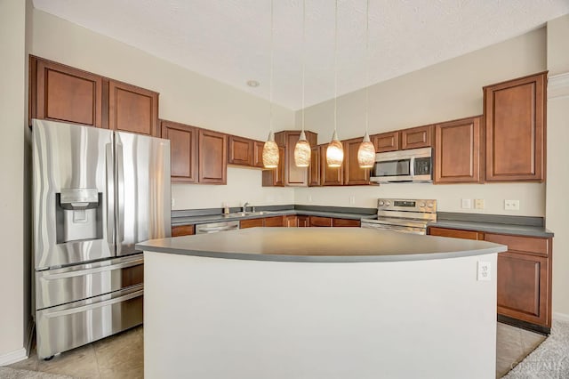 9298 Greenery Ct, Deerfield Twp, OH 45140 - kitchen featuring appliances with stainless steel finishes, dark countertops, a sink, a kitchen island, and brown cabinets
