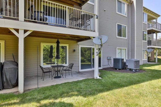 715 Castlegate Ln Unit 102, Springfield Twp, OH 45231 - back of property featuring central AC unit, a lawn, a patio area, and a balcony
