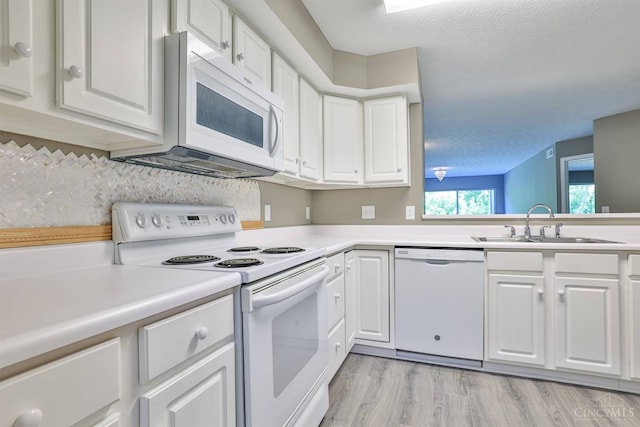 715 Castlegate Ln Unit 102, Springfield Twp, OH 45231 - kitchen featuring white appliances, a sink, white cabinets, and a textured ceiling