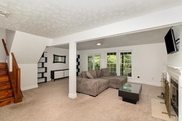 1732 Emerald Glade Ln Unit 6D, Anderson Twp, OH 45255 - living room featuring stairway, light colored carpet, baseboards, a fireplace with flush hearth, and a textured ceiling