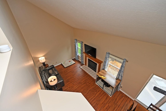 557 Hamblin Dr, Union Twp, OH 45255 - living room featuring wood finished floors, a tiled fireplace, a textured ceiling, vaulted ceiling, and baseboards