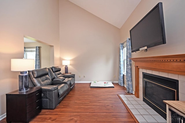 557 Hamblin Dr, Union Twp, OH 45255 - living room with a tiled fireplace, wood finished floors, high vaulted ceiling, and baseboards