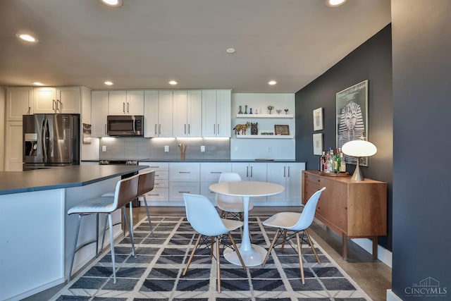 2401 Ingleside Ave Unit 10D, Cincinnati, OH 45206 - kitchen with stainless steel appliances, dark countertops, open shelves, white cabinets, and recessed lighting