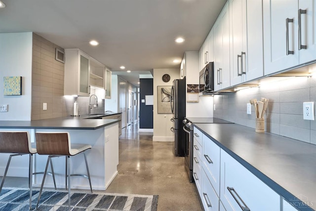 2401 Ingleside Ave Unit 10D, Cincinnati, OH 45206 - kitchen with electric range, finished concrete floors, freestanding refrigerator, tasteful backsplash, and white cabinets