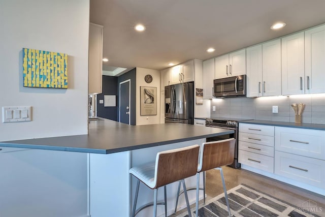 2401 Ingleside Ave Unit 10D, Cincinnati, OH 45206 - kitchen featuring appliances with stainless steel finishes, dark countertops, backsplash, recessed lighting, and white cabinetry