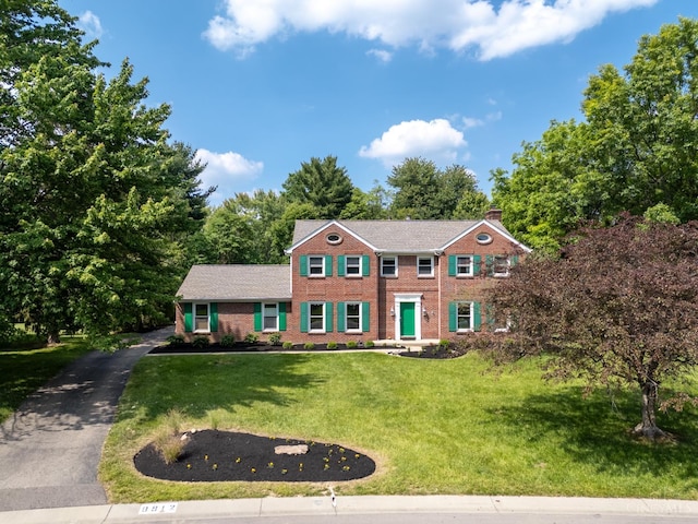 8912 Chapelsquare Ln, Symmes Twp, OH 45249 - view of front of property featuring brick siding, a front yard, a chimney, and view of wooded area