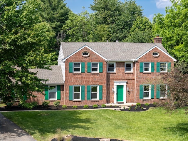 8912 Chapelsquare Ln, Symmes Twp, OH 45249 - colonial house with a chimney, roof with shingles, brick siding, and a front yard