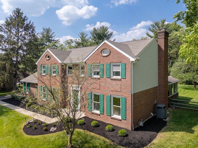 8912 Chapelsquare Ln, Symmes Twp, OH 45249 - view of front of property with brick siding, a chimney, central air condition unit, a front yard, and roof with shingles