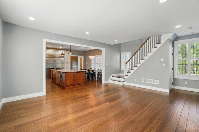 5757 W Fork Rd, Green Twp, OH 45247 - unfurnished living room featuring stairway, hardwood / wood-style floors, baseboards, recessed lighting, and a sink