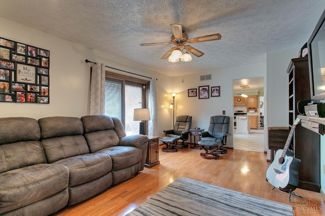 3169 John Gray Rd, Colerain Twp, OH 45251 - living area featuring a ceiling fan, light wood finished floors, and a textured ceiling