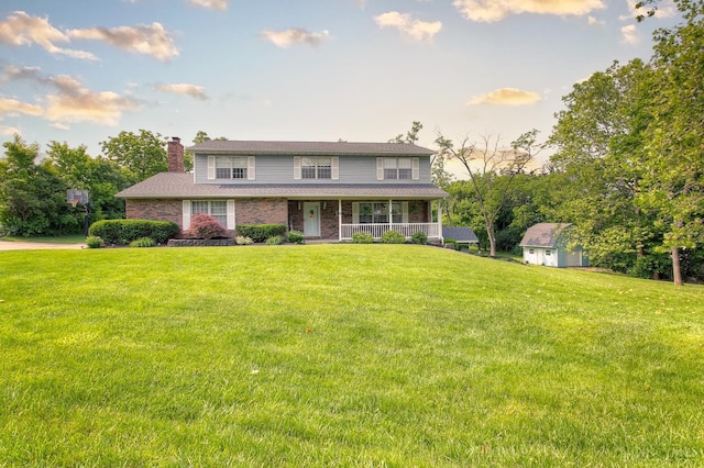 3169 John Gray Rd, Colerain Twp, OH 45251 - view of front of property with covered porch, a chimney, a front yard, and brick siding