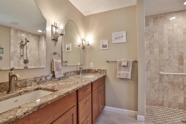 8750 E Kemper Rd, Symmes Twp, OH 45249 - bathroom featuring tiled shower, double vanity, baseboards, and recessed lighting
