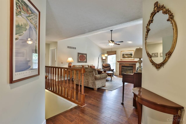 8750 E Kemper Rd, Symmes Twp, OH 45249 - living area featuring a ceiling fan, a tile fireplace, dark wood-style flooring, and vaulted ceiling