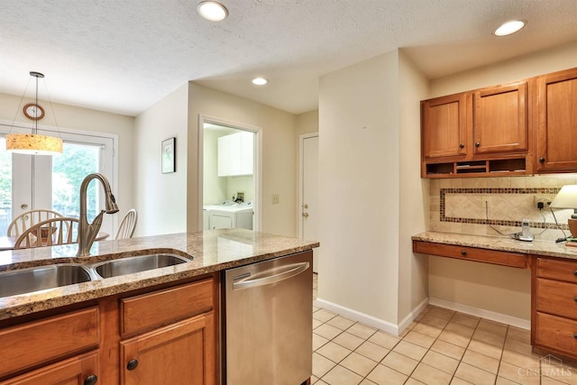 8750 E Kemper Rd, Symmes Twp, OH 45249 - kitchen featuring stainless steel dishwasher, a sink, washer and clothes dryer, brown cabinets, and pendant lighting