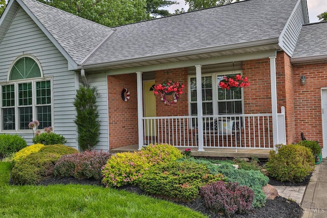 8750 E Kemper Rd, Symmes Twp, OH 45249 - view of exterior entry featuring roof with shingles, brick siding, and covered porch