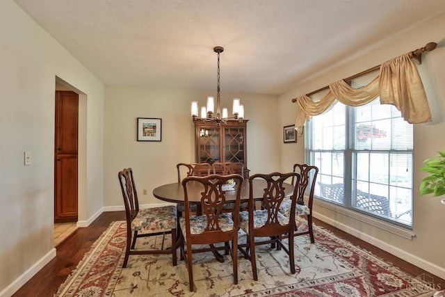 8750 E Kemper Rd, Symmes Twp, OH 45249 - dining space with a chandelier, wood finished floors, and baseboards
