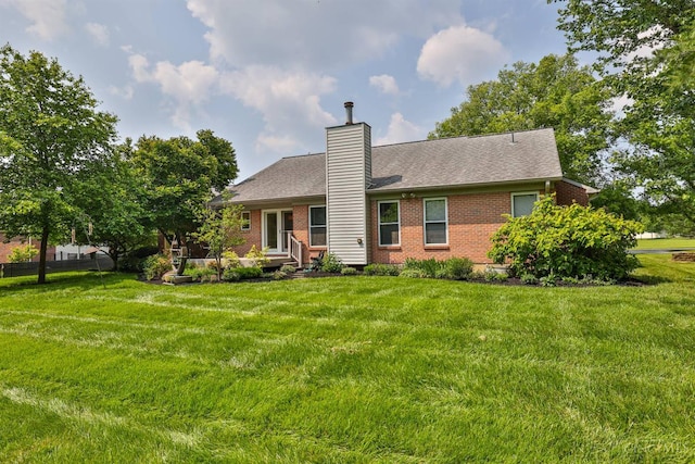 8750 E Kemper Rd, Symmes Twp, OH 45249 - back of house with brick siding, a yard, and a chimney