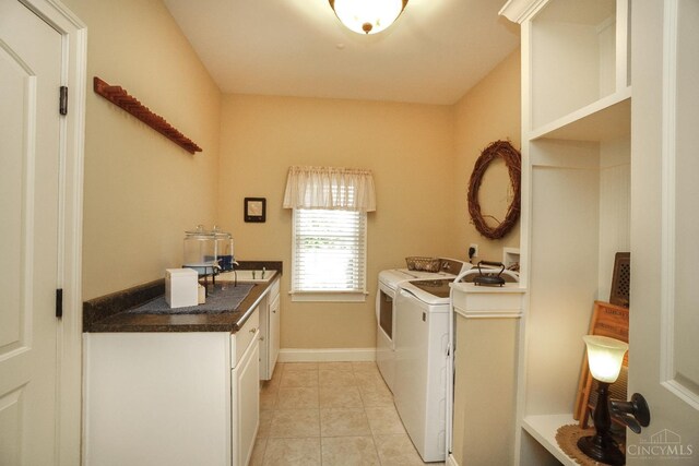 4625 Guildford Dr, West Chester, OH 45069 - laundry area featuring cabinet space, washing machine and dryer, light tile patterned flooring, and baseboards
