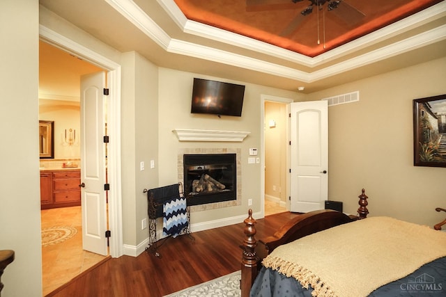 4625 Guildford Dr, West Chester, OH 45069 - bedroom featuring wood finished floors, a raised ceiling, ornamental molding, a tiled fireplace, and ensuite bathroom