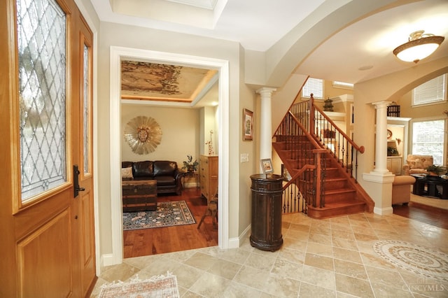 4625 Guildford Dr, West Chester, OH 45069 - entrance foyer featuring decorative columns, arched walkways, a tray ceiling, and stairs