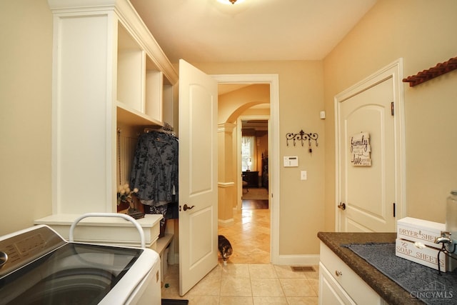 4625 Guildford Dr, West Chester, OH 45069 - laundry room featuring arched walkways, independent washer and dryer, light tile patterned floors, and baseboards