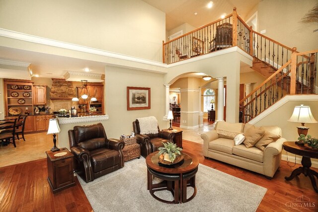 4625 Guildford Dr, West Chester, OH 45069 - living area with decorative columns, dark wood-type flooring, a towering ceiling, arched walkways, and stairway