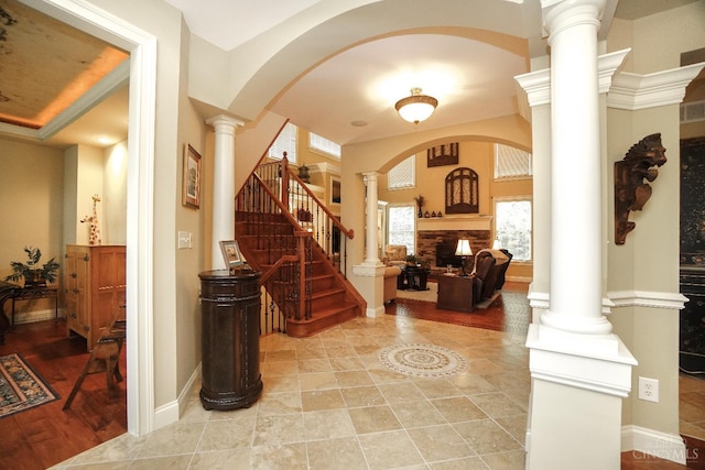 4625 Guildford Dr, West Chester, OH 45069 - foyer with ornate columns, arched walkways, a fireplace, stairs, and baseboards