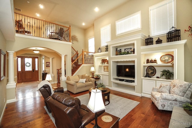 4625 Guildford Dr, West Chester, OH 45069 - living area featuring ornate columns, a high ceiling, arched walkways, healthy amount of natural light, and dark wood-style flooring