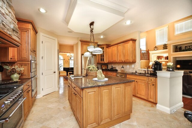 4625 Guildford Dr, West Chester, OH 45069 - kitchen with a sink, appliances with stainless steel finishes, decorative backsplash, a center island, and brown cabinetry