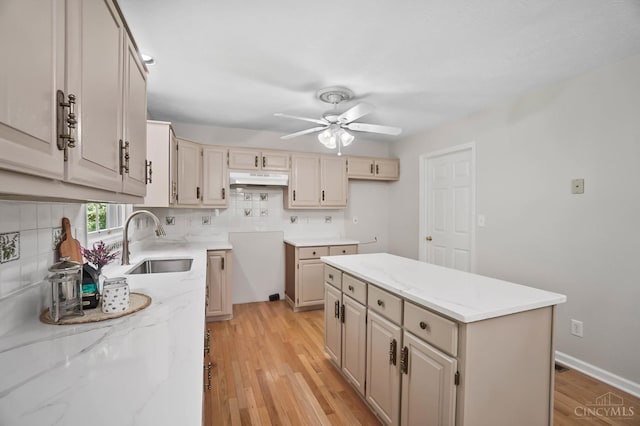 2193 Phillips Rd, Union Twp, OH 45036 - kitchen with a ceiling fan, light wood-type flooring, a center island, backsplash, and light stone counters