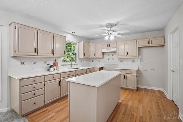 2193 Phillips Rd, Union Twp, OH 45036 - kitchen with under cabinet range hood, backsplash, light wood finished floors, and a kitchen island