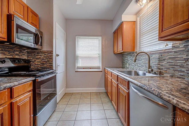 3947 Ruth Ln, Cheviot, OH 45211 - kitchen with appliances with stainless steel finishes, backsplash, light tile patterned floors, and brown cabinetry