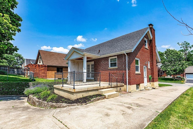 3947 Ruth Ln, Cheviot, OH 45211 - view of front of home featuring a porch, a chimney, brick siding, and a shingled roof