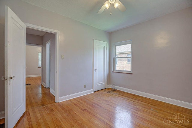3947 Ruth Ln, Cheviot, OH 45211 - unfurnished bedroom featuring multiple windows, light wood finished floors, and a ceiling fan