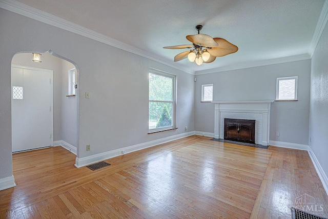 3947 Ruth Ln, Cheviot, OH 45211 - unfurnished living room with a ceiling fan, ornamental molding, arched walkways, light wood-style floors, and a brick fireplace