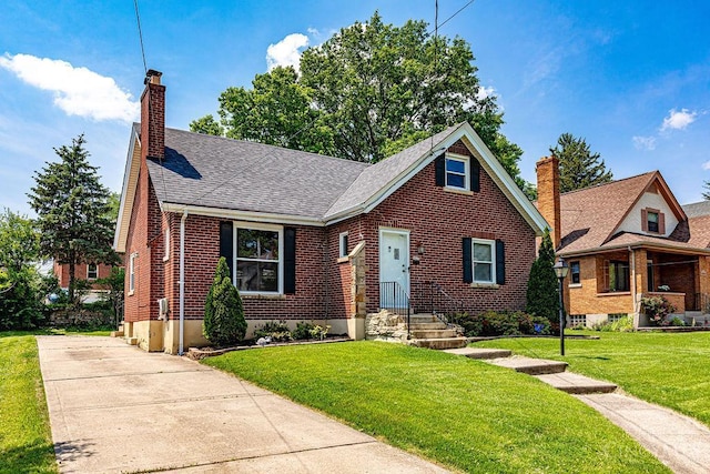 3947 Ruth Ln, Cheviot, OH 45211 - view of front facade with a chimney, brick siding, a front yard, and a shingled roof