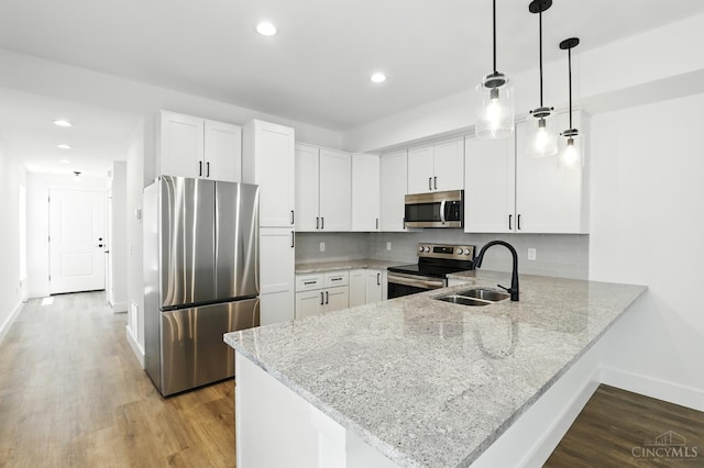 2356 Concord St, Cincinnati, OH 45206 - kitchen featuring appliances with stainless steel finishes, a peninsula, light wood-style floors, white cabinetry, and recessed lighting