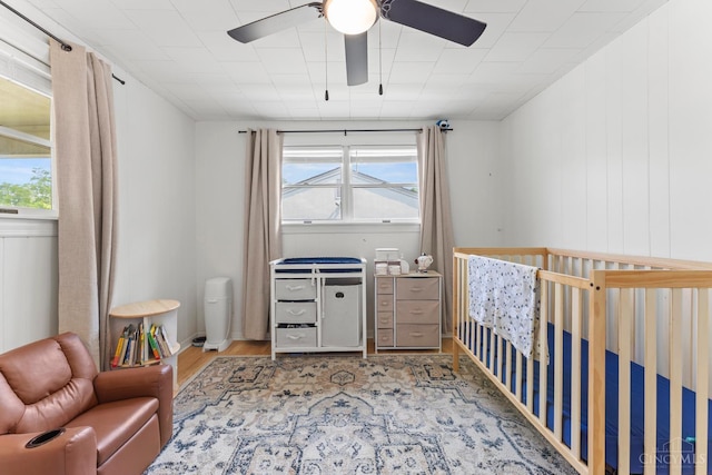 6530 Cliff Ridge Ln, Columbia Twp, OH 45213 - bedroom featuring wood finished floors, a crib, and a ceiling fan