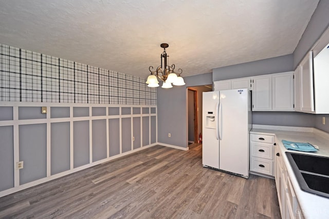 9660 N Dixie Hwy, Franklin Twp, OH 45005 - kitchen featuring white refrigerator with ice dispenser, a chandelier, wood finished floors, white cabinets, and hanging light fixtures