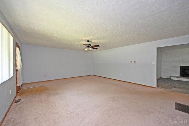 9660 N Dixie Hwy, Franklin Twp, OH 45005 - carpeted empty room with a ceiling fan, a fireplace, baseboards, and a textured ceiling