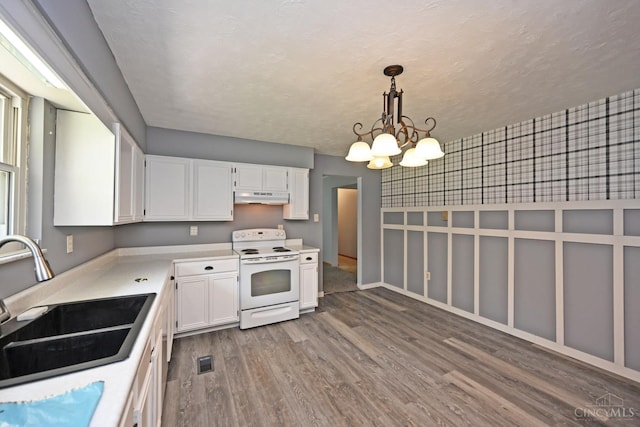 9660 N Dixie Hwy, Franklin Twp, OH 45005 - kitchen with white range with electric cooktop, under cabinet range hood, a sink, white cabinets, and wood finished floors