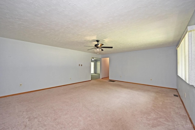 9660 N Dixie Hwy, Franklin Twp, OH 45005 - spare room featuring light carpet, a ceiling fan, healthy amount of natural light, baseboards, and a textured ceiling