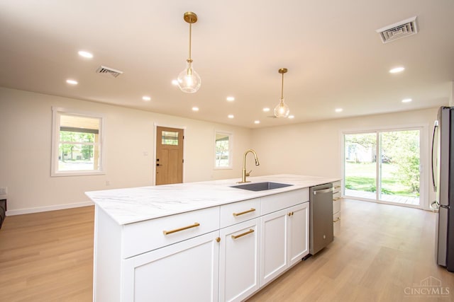 106 Fiord Dr, Lakengren, OH 45320 - kitchen with stainless steel appliances, a sink, light wood-style flooring, white cabinetry, and healthy amount of natural light