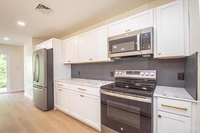 106 Fiord Dr, Lakengren, OH 45320 - kitchen featuring appliances with stainless steel finishes, light wood finished floors, backsplash, white cabinetry, and recessed lighting